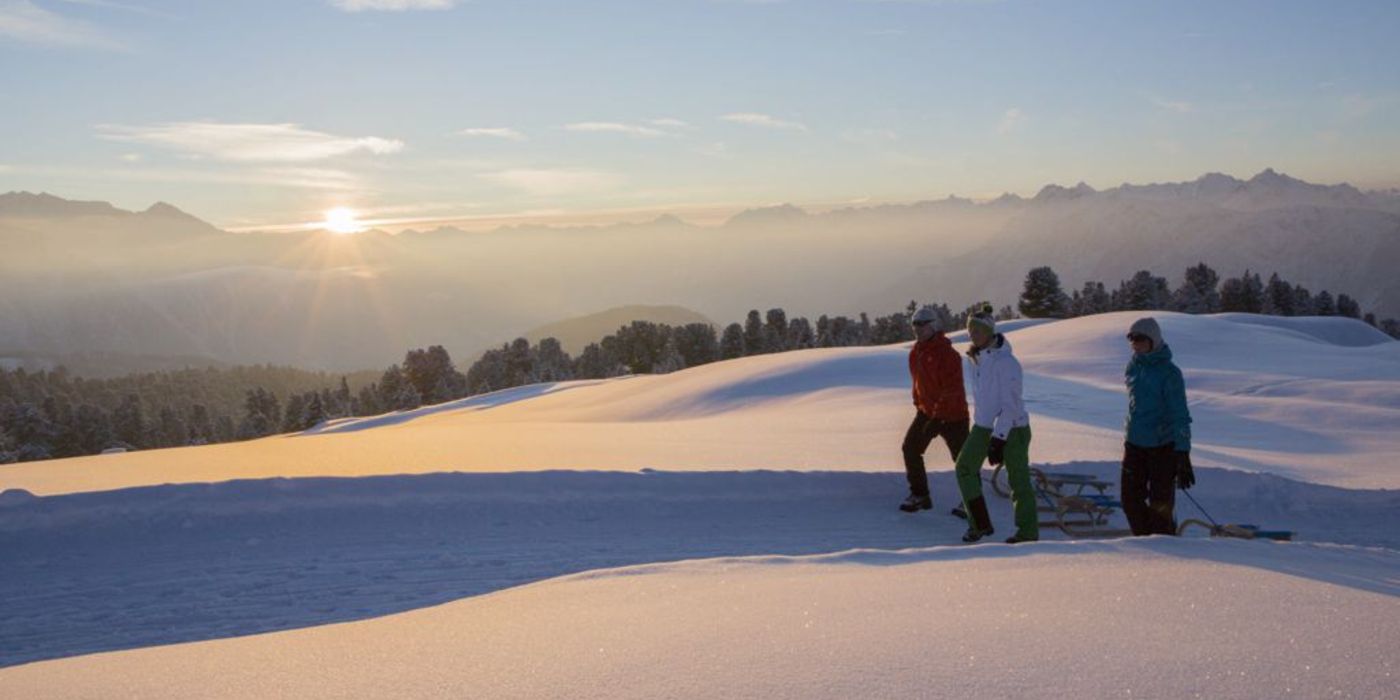 drei Personen beim spazieren durch traumhafte Winterlandschaft